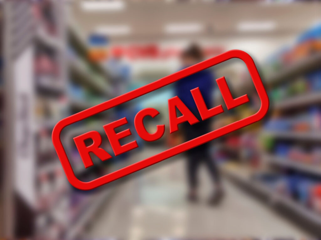 A blurry photo of a grocery store isle with RECALL across the photo