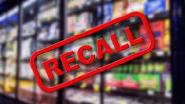 Recall written in red letter over a blurred photo of the frozen section in grocery store