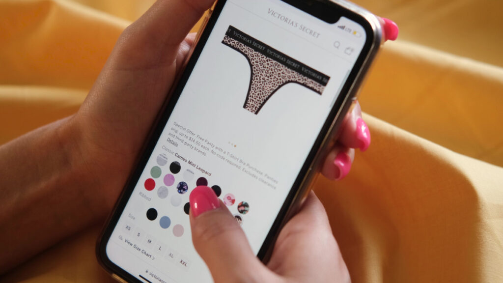 Closeup shopping young woman chooses underwear in online store.