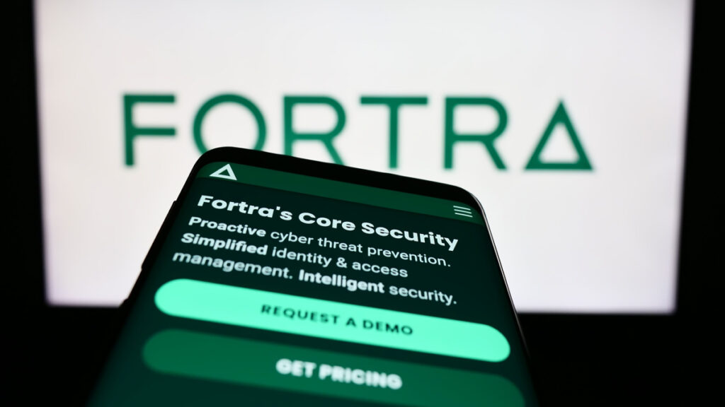 The Forta logo is seen on a desktop computer behind a smartphone also showing a Fortra screen, representing the Fortra data breach class action