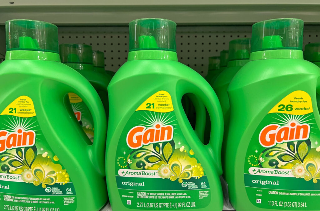 Three bottles of Gain laundry detergent on store shelf.