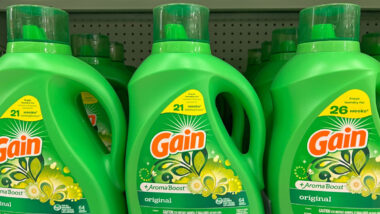 Three bottles of Gain laundry detergent on store shelf.