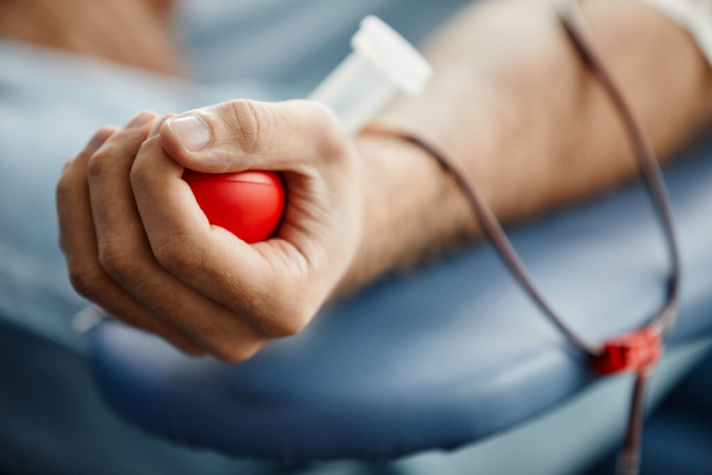 A person squeezing a small ball while having blood drawn representing the Biomat, Talecris Plasma and Interstate Blood Bank BIPA class action lawsuit settlement.
