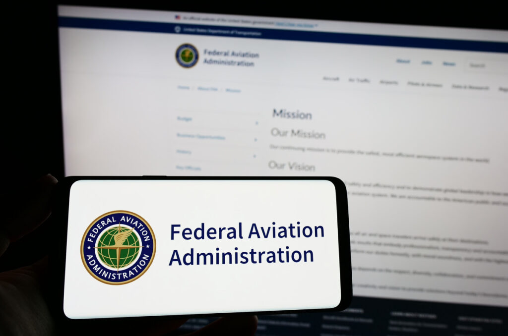 Person holding smartphone with seal of US Federal Aviation Administration (FAA) on screen in front of website representing the FAA air traffic controller EEOC settlement.