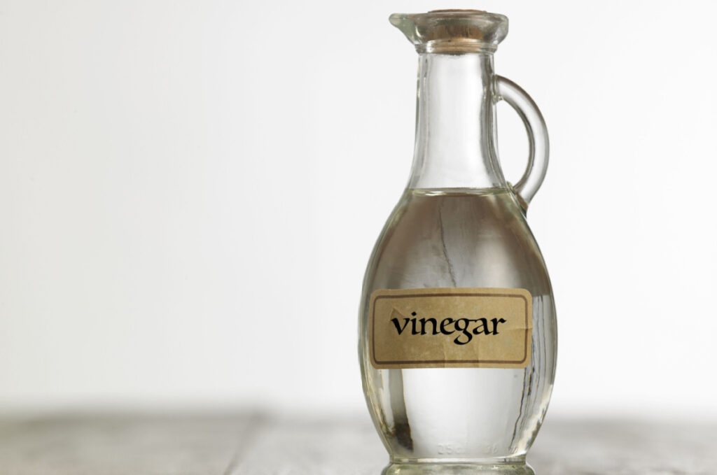 Clear glass bottle with a label that reads "Vinegar," representing the vinegar pollution lawsuit.