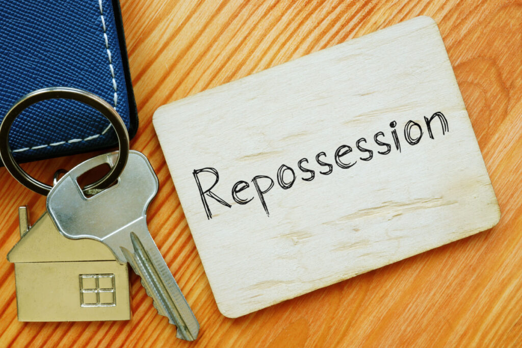 House keys next to a note that reads"repossession" representing the General Credit Acceptance settlement.