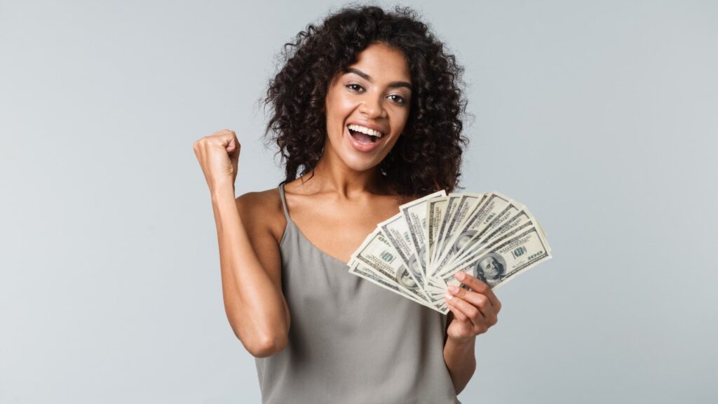 Happy woman with cash in hand, representing settlement checks in the mail.