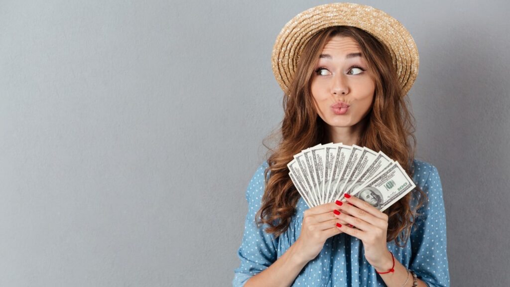 woman happy with money in hand, representing settlement checks in the mail.