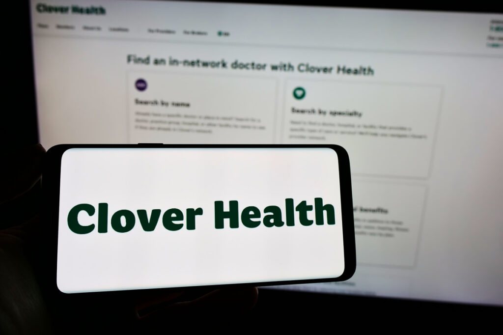 Person holding cellphone with logo of healthcare company Clover Health