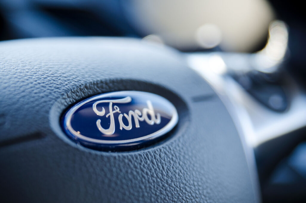 Ford sign on steering wheel close up.