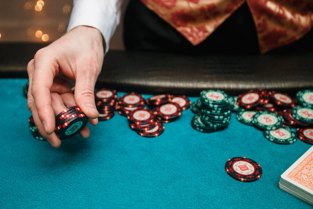 Close up of a casino worker dealing poker chips, representing the Delaware casino data breach.