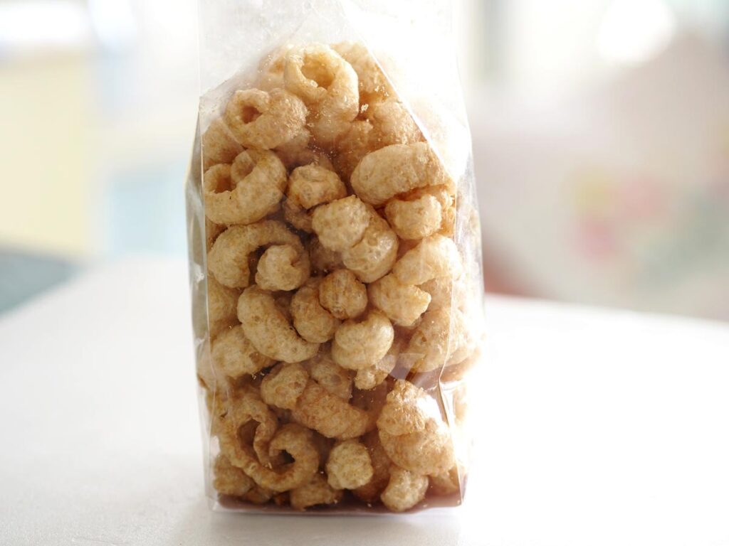 Close up of a clear bag filled with pork rinds, representing the Mitten Gourmet recall.