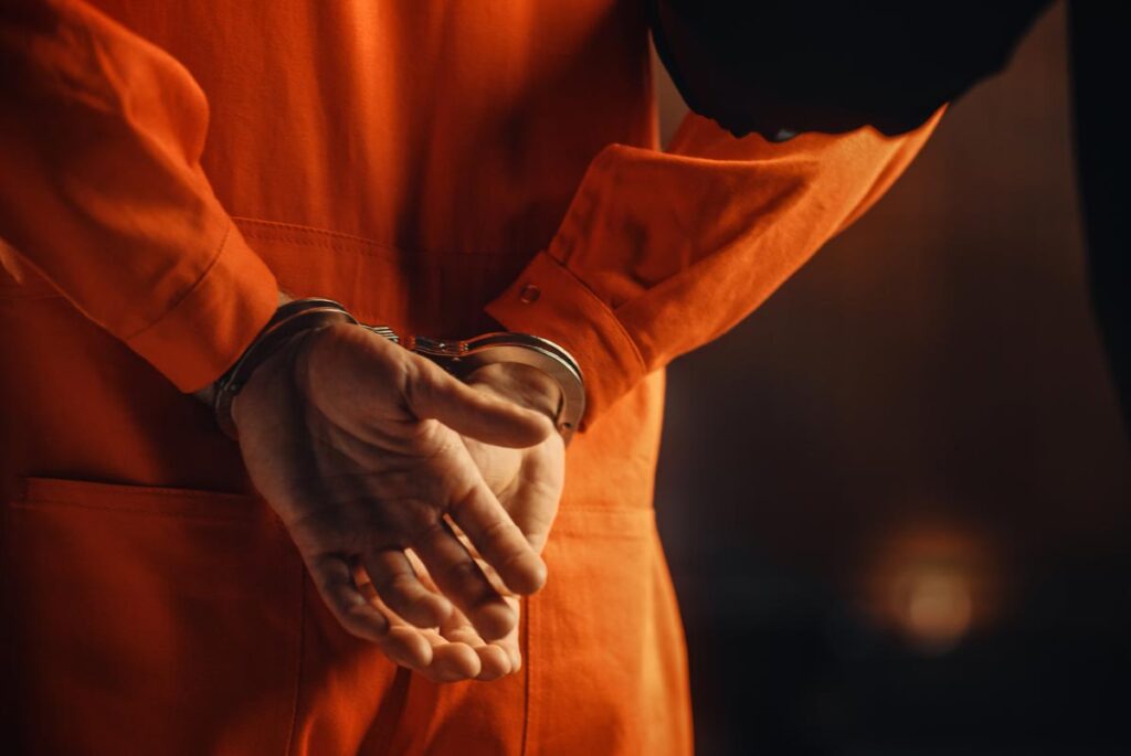 Close up of a prisoner in handcuffs, representing the Inmate Services class action settlement.