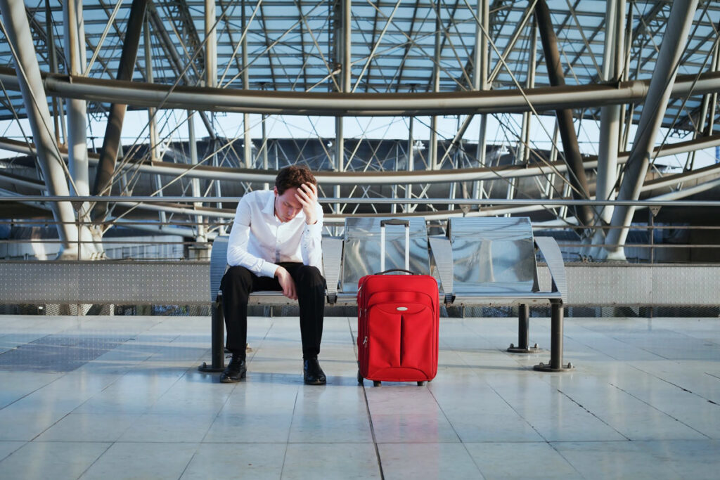 Stressed out male traveler in an airport Representing the Department of Transportation's plans for airlines to compensate stranded passengers.