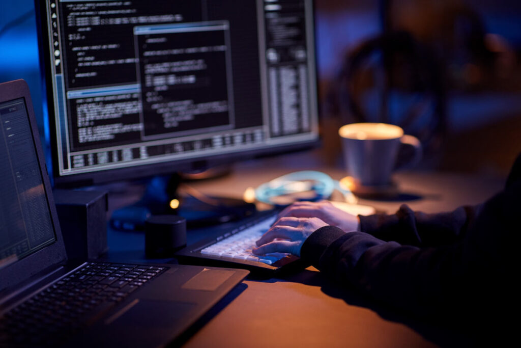 Close up of a cybercriminal using a computer to hack, representing the TMX Finance data breach class action.