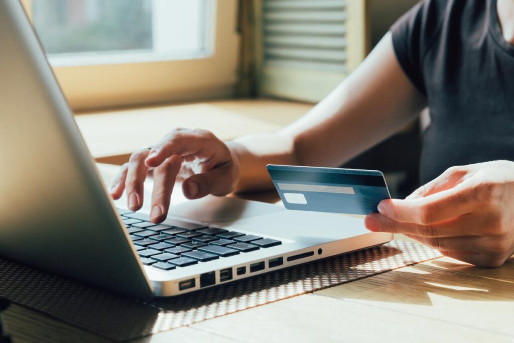 Close up of a woman typing her card information into a computer, representing The Shade Store pricing class action.