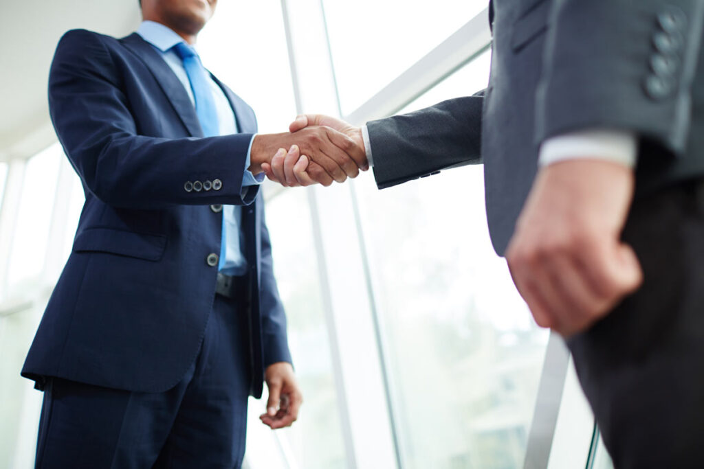 Close up of two businessman shaking hands, Representing the Medical Properties Trust class action.
