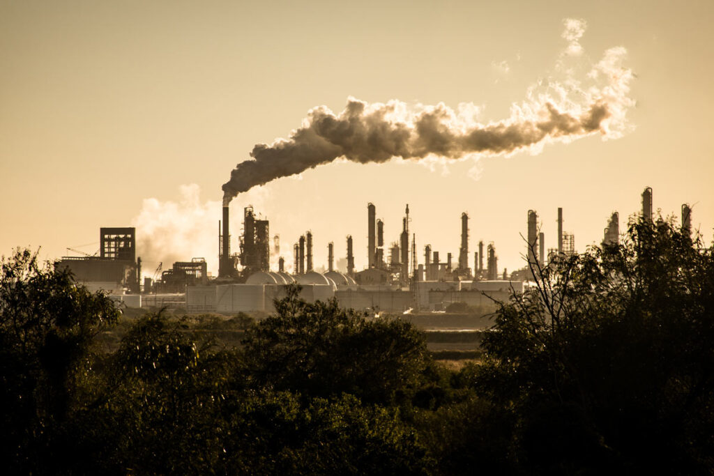 Silhouette of an industrial area with heavy pollution smoke, representing recent environmental lawsuits.