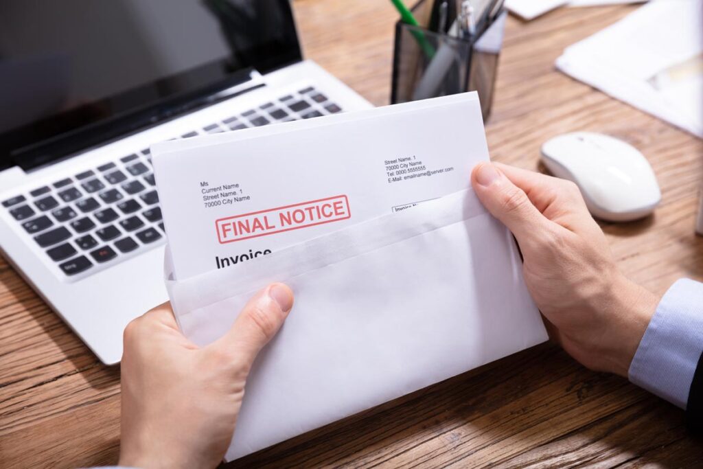 Close up of a persons hands opening a letter with a stamp that reads, Overdue, representing the Convergent Outsourcing debt collection restitution settlement.