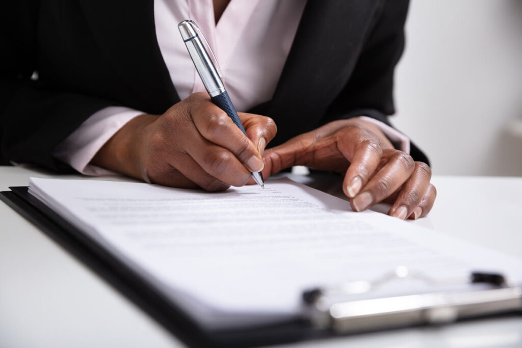 Close up of a woman's hands filling out a job application, representing the Computer Generated Solutions FCRA class action lawsuit settlement.