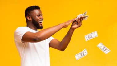 Man happy with money in hand "making it rain", representing recent settlement checks in the mail.