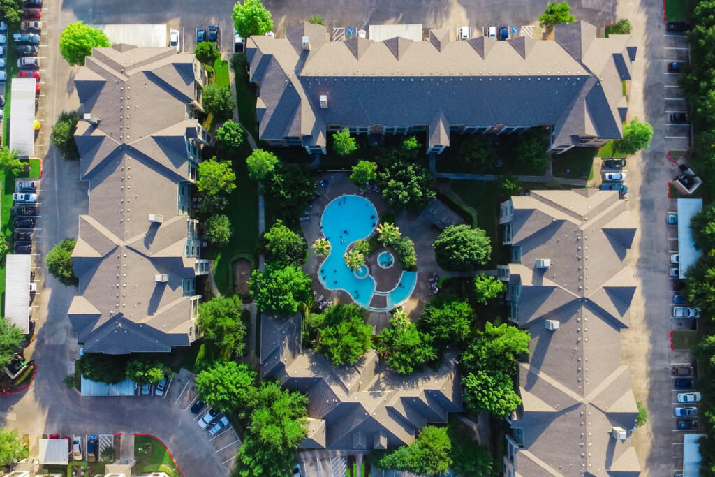 Aerial view of an apartment complex with a pool, representing the Vasona Management familial status discrimination class action lawsuit settlement with the California Civil Rights Department.