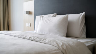 White pillows and bedding on a made bed, representing the Macy's sheets settlement