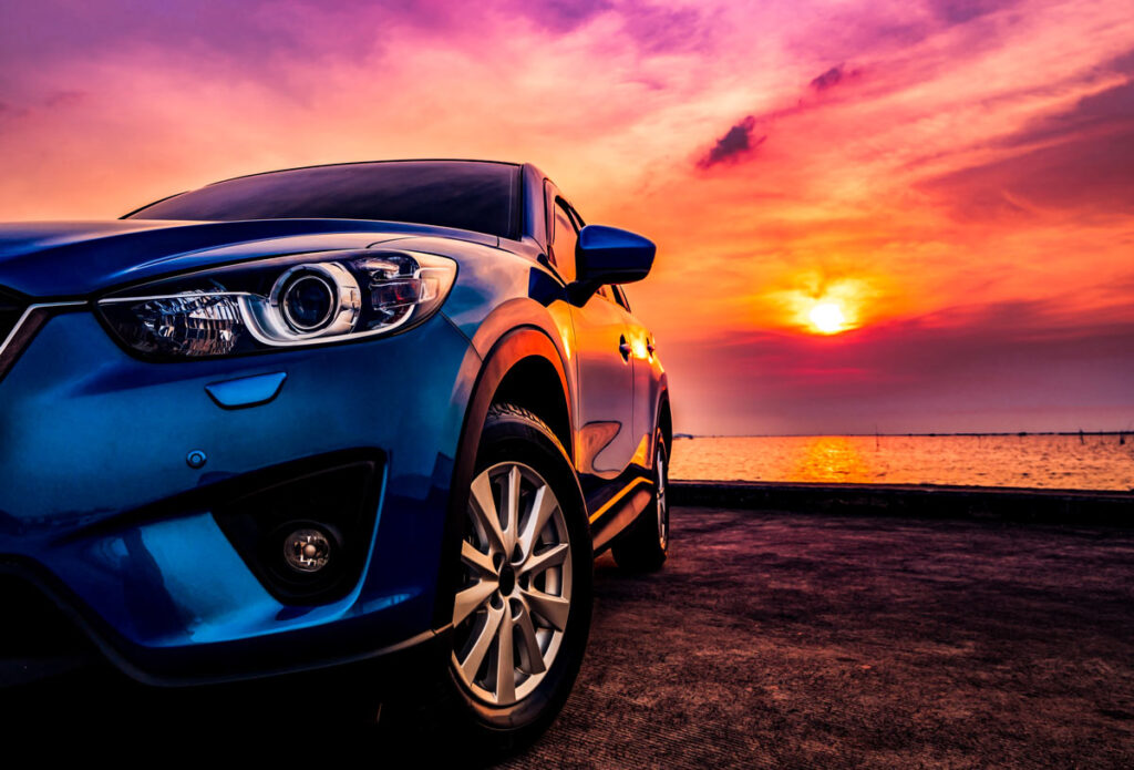 Close up of a blue car against an intense sunset sky, representing the Ford recall.