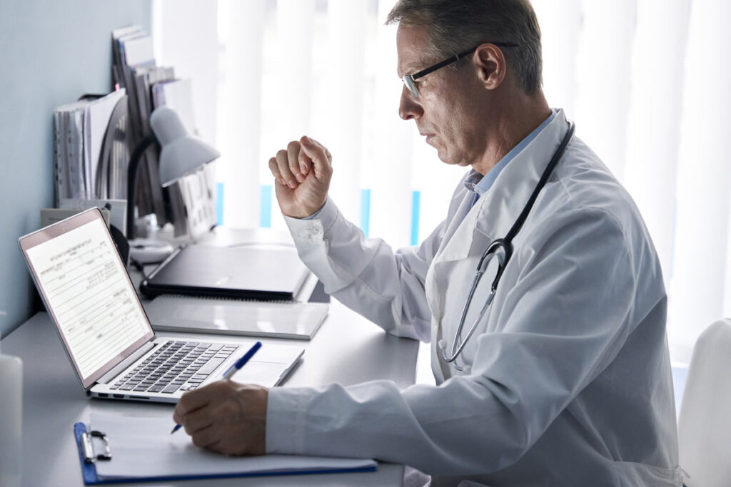 A doctor using a computer, representing the Michigan Avenue Immediate Care data breach settlement.