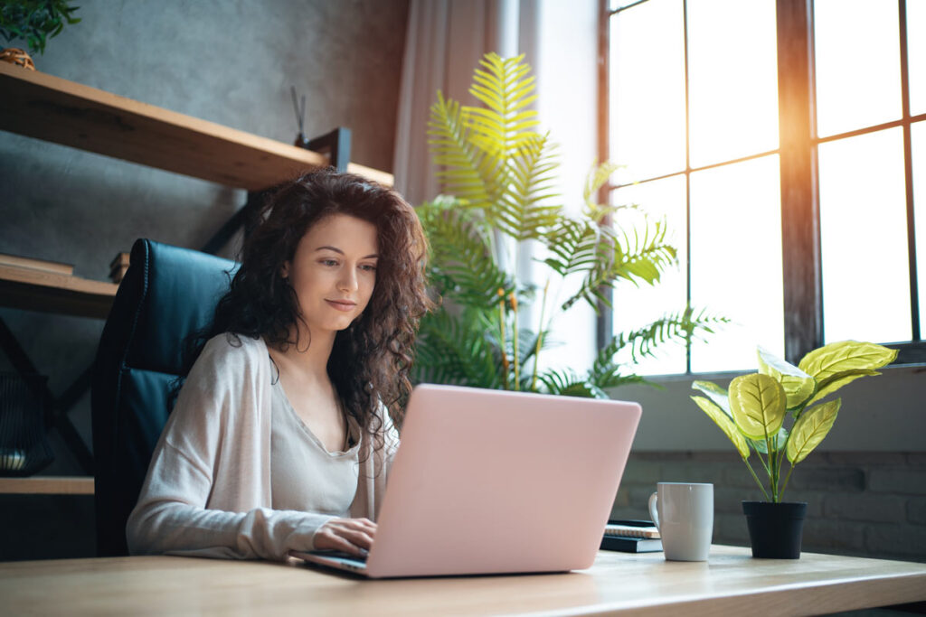 A woman using her laptop at home, representing the Giftly merchant advertising class action settlement.