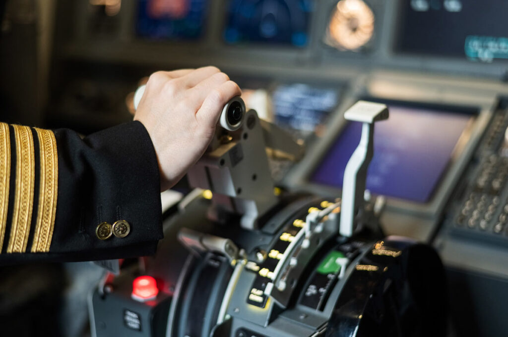 Close up of female pilots hand on plane engine control stick, representing the FAA bill.