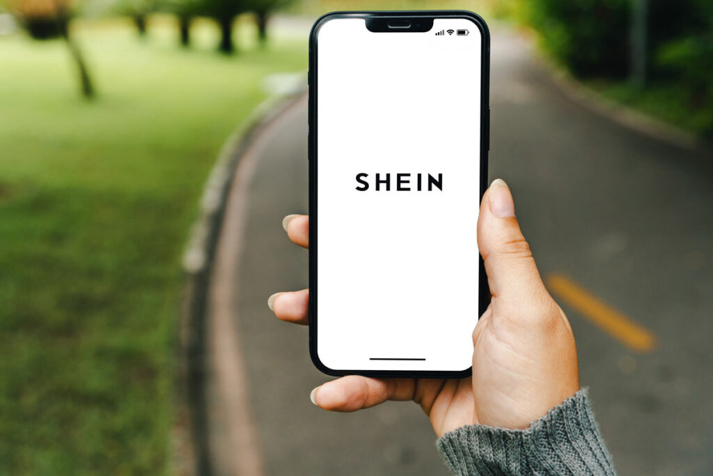 SHEIN logo displayed on a smartphone screen, representing the temu lawsuit.