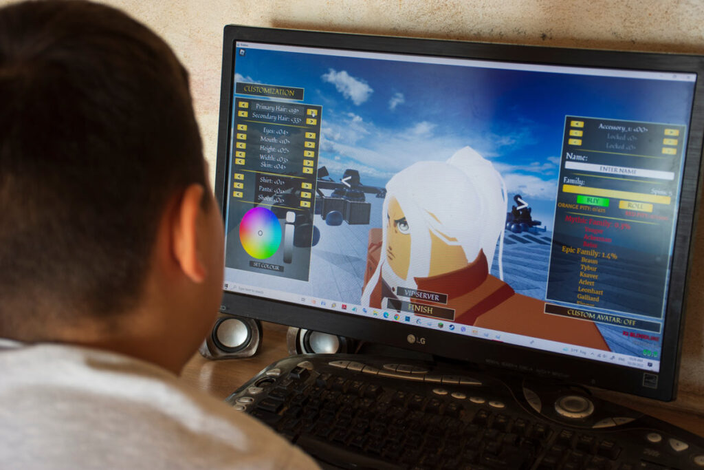 A young boy building a Roblox game on a computer, representing the Roblox data breach.