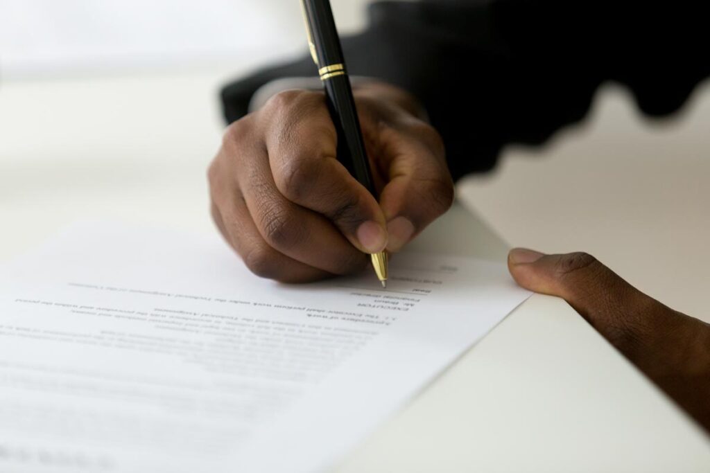 Close up of a hand signing a document, representing the Blind Side lawsuit.