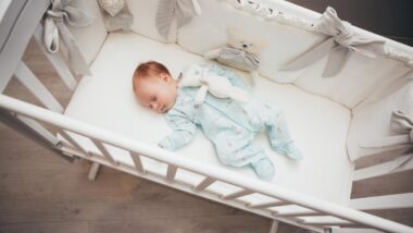Baby sleeping in a crib, representing the inclined sleeper and crib bumper rules.