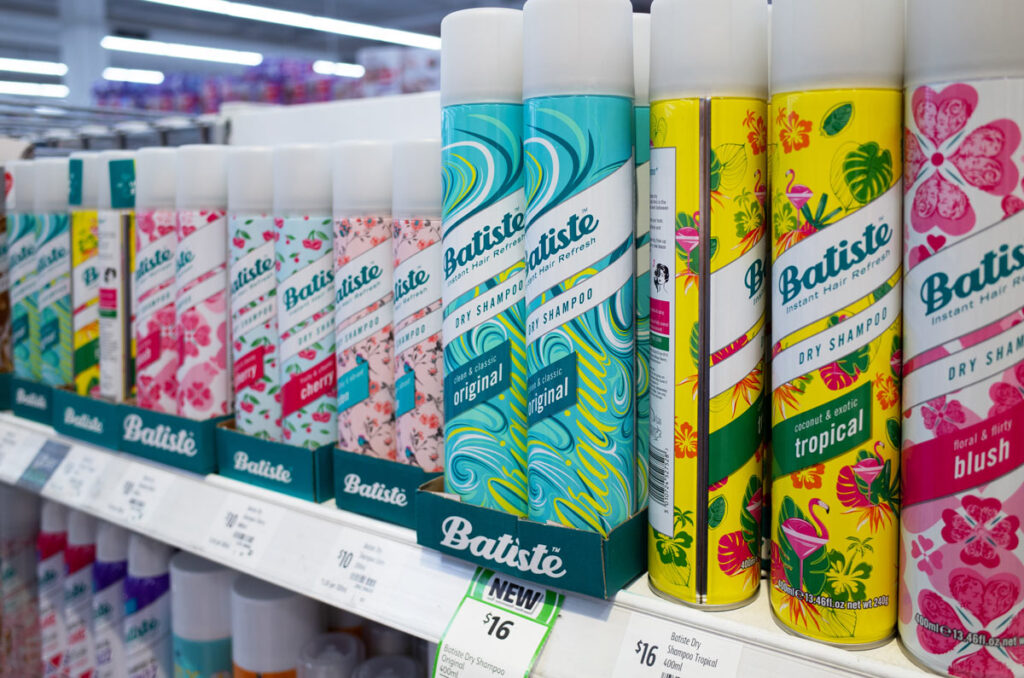 Batiste dry shampoo products on a store shelf, representing the Batiste class action lawsuit settlement.