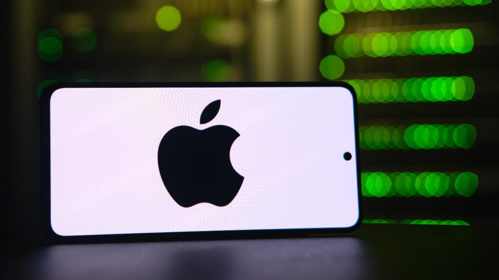 Apple logo on smartphone in front of server stack.