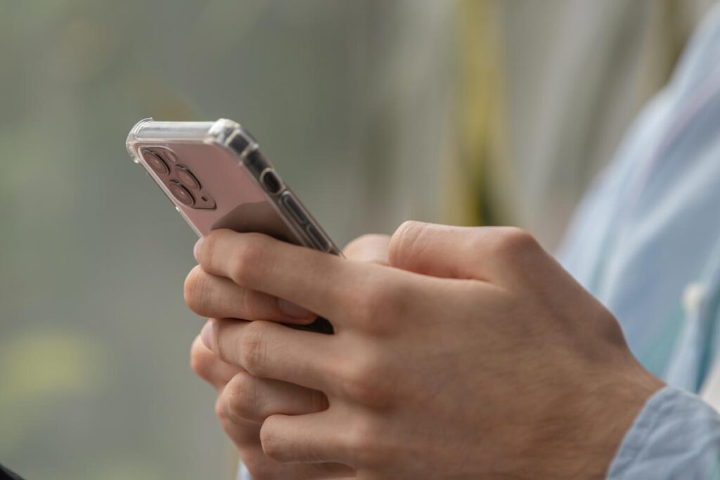 Close up of a males hands texting on a smartphone, representing the Harry and David class action.