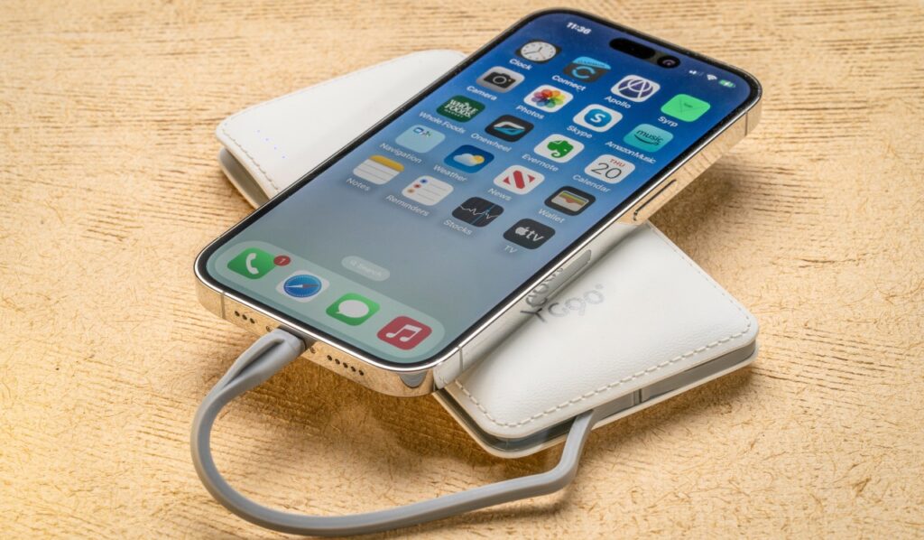 Apple iPhone is being charged from a portable battery pack.