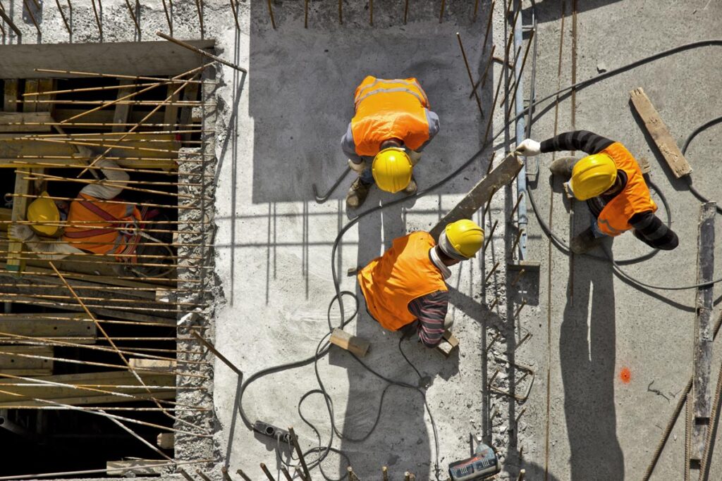 Aerial view of construction workers working on a job site, representing construction wage calculations.
