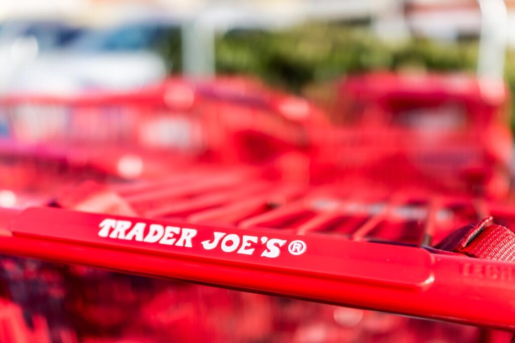 Close up of Trader Joes logo on a shopping cart, representing recent Trader Joe's recalls.