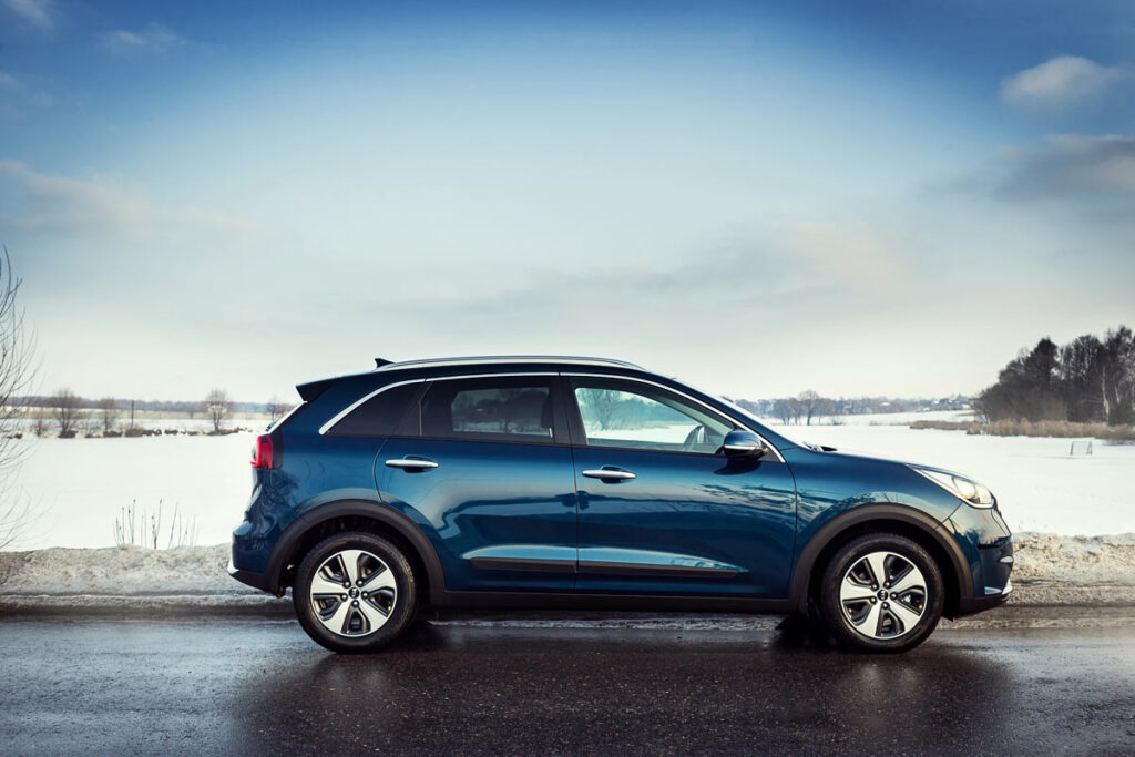 A blue Kia Niro driving along the road, representing the Kia Niro recall.