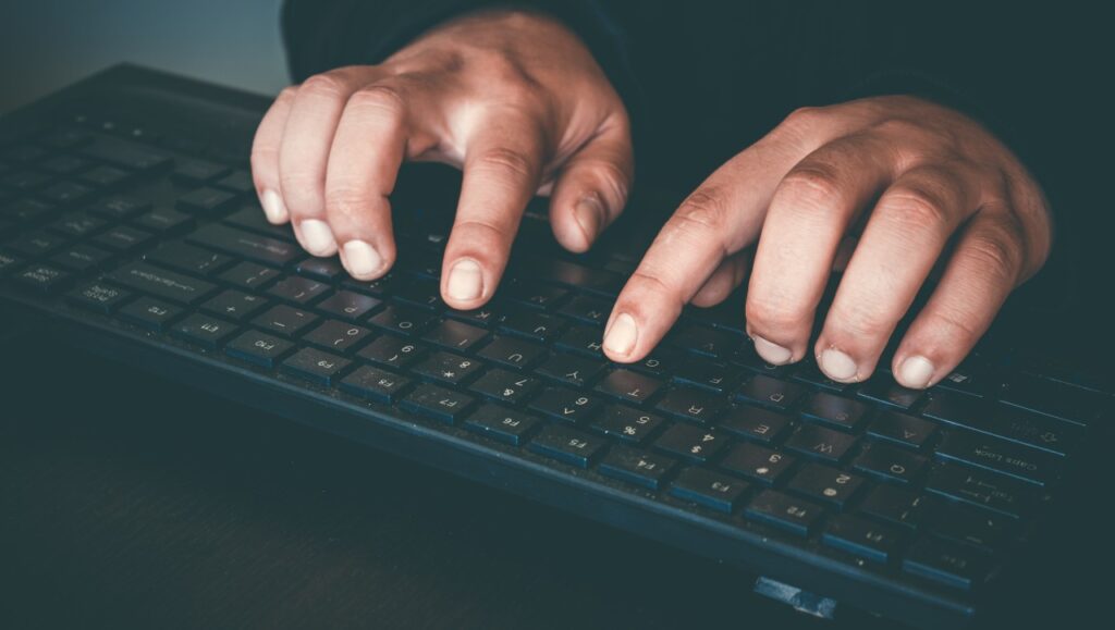 Hacker stealing data concept. Internet security breach. Man hands touching keyboard, representing the Allwell Behavioral Health data breach settlement.