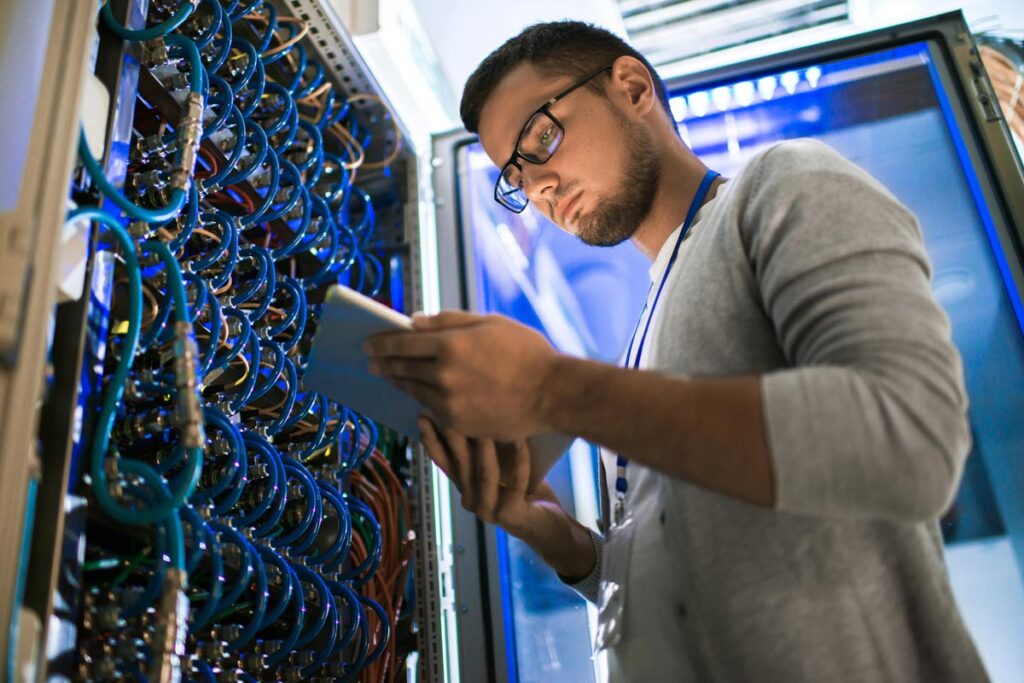 A computer technician working in a server room, representing the City of Dallas data breach.