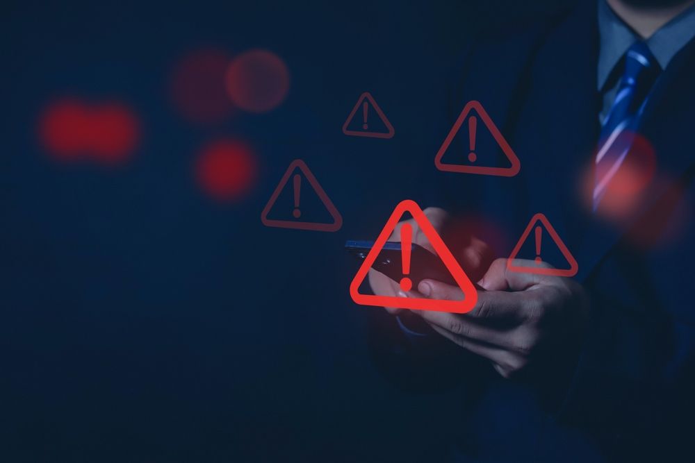 employee with warning triangle sign for warning error representing summer data breaches.