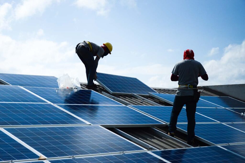 Workers installing solar panels on a house, representing the Better Earth class action.