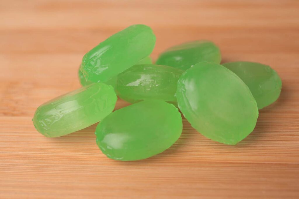 Close up of green lozenges on a table, representing the Ricola class action.