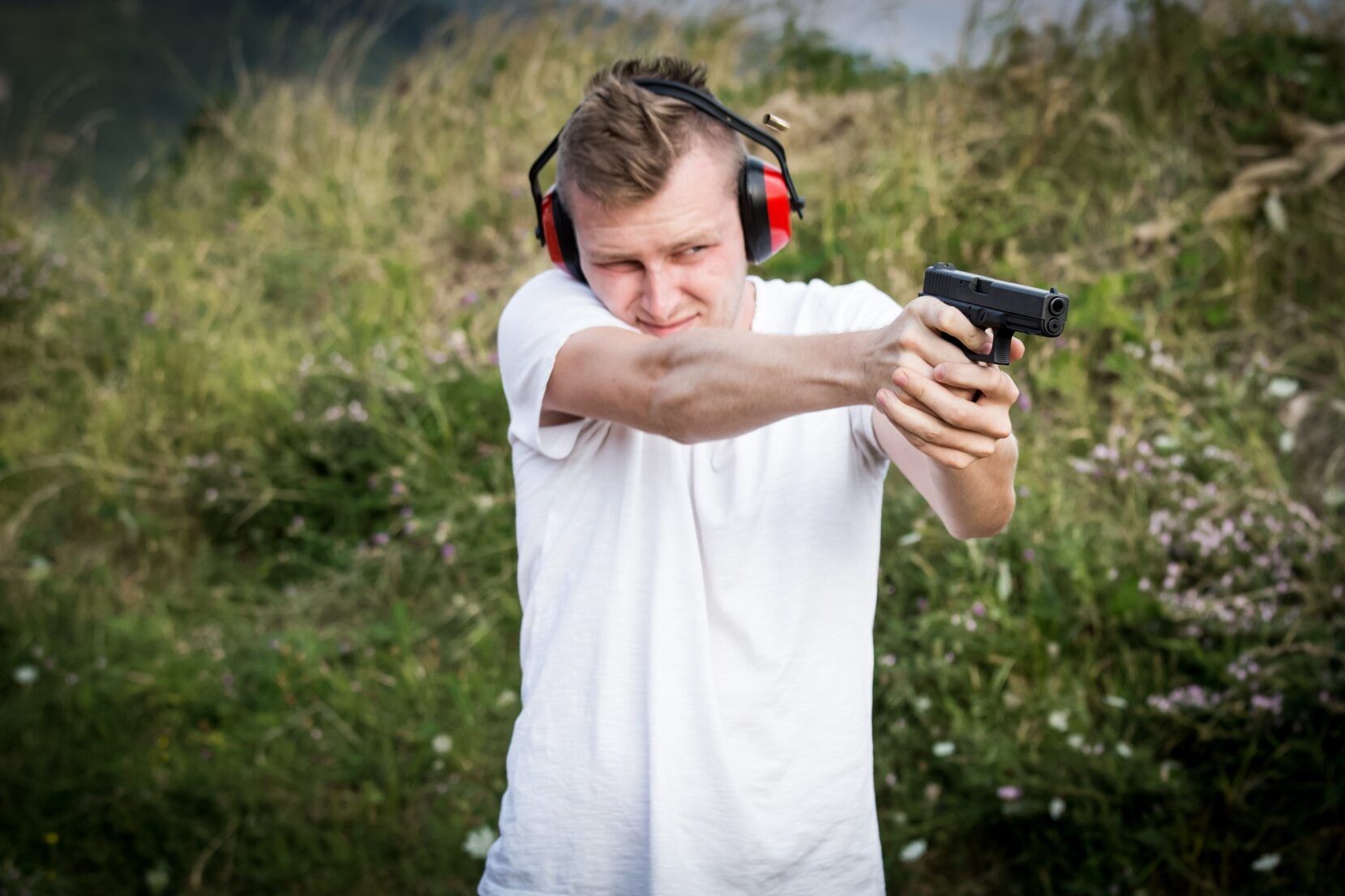 A man shooting a handgun, representing the Glock defect class action lawsuit.