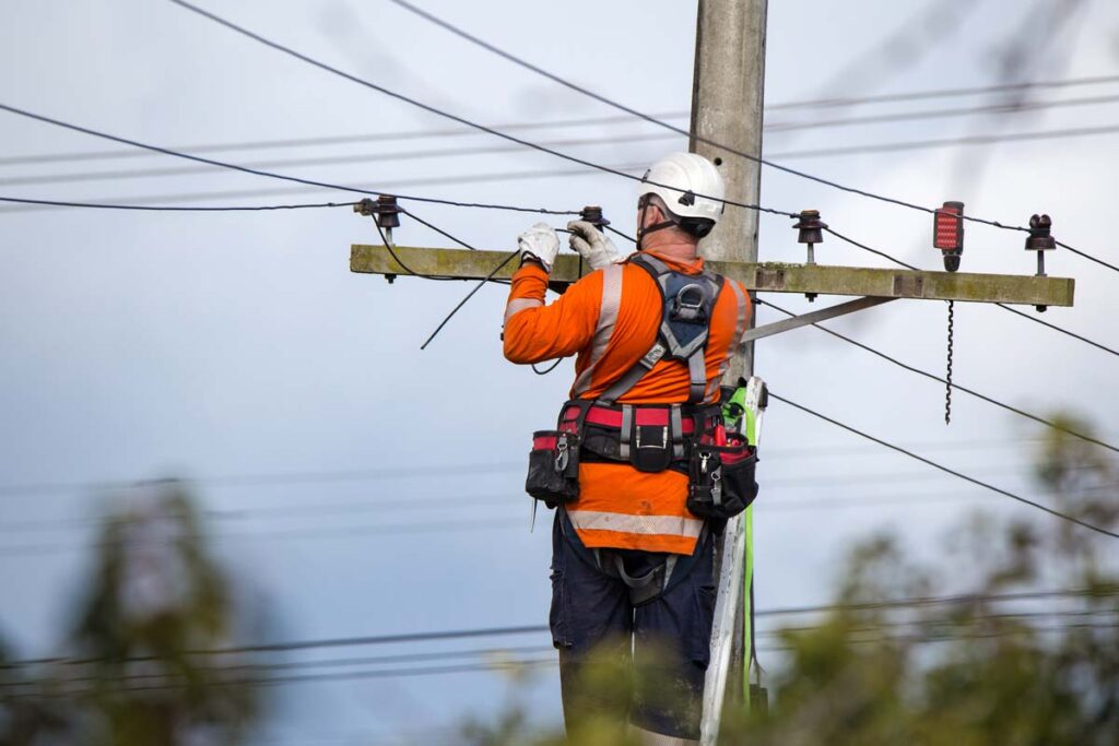 A worker working on power lines, representing the McGee Electric settlement.