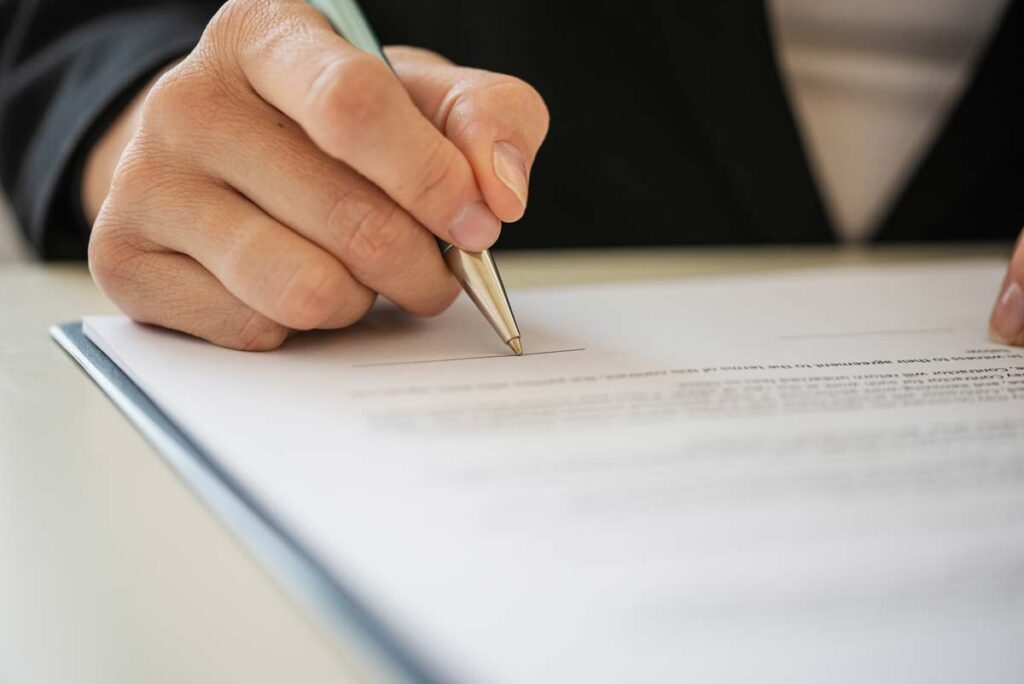 Close up of a businessman's hand signing a document, representing the California food chemical ban.